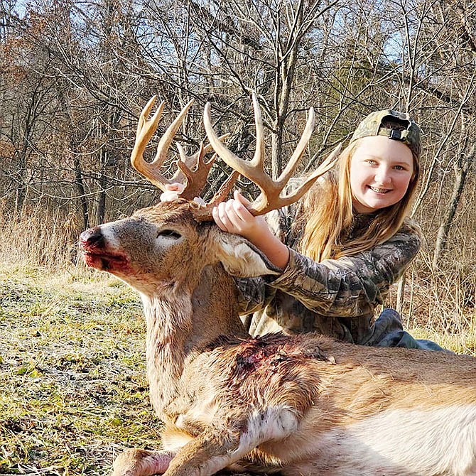 Madison Plybon, 13, poses beside a buck she harvested during the most recent deer hunting season. The buck was the first she'd taken bow-hunting and boasted 15 points.