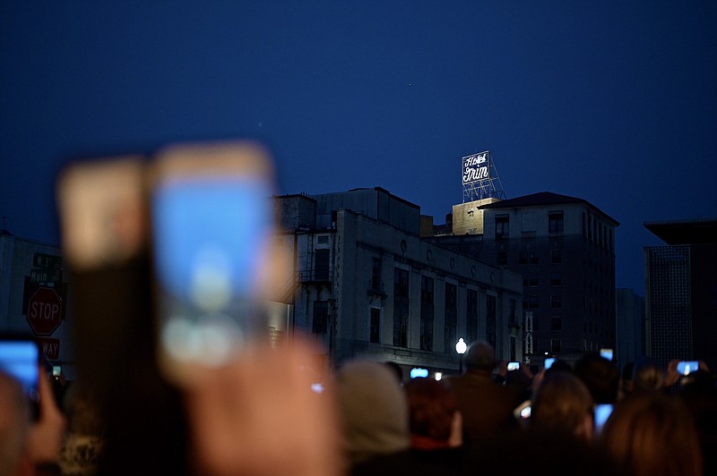 Attendees of the Grim Hotel lighting ceremony hold their phones out to record and photograph the lighting of the sign for the first time in 30 years outside of the Perot Theatre on Tuesday, January 20, 2020, in Texarkana, Texas.