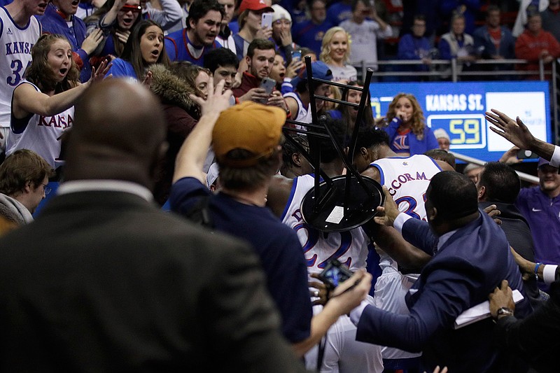 A fight between players spills into the crowd during the second half of an NCAA college basketball game between Kansas and Kansas State in Lawrence, Kan., Tuesday, Jan. 21, 2020. Kansas defeated Kansas State 81-59. (AP Photo/Orlin Wagner)