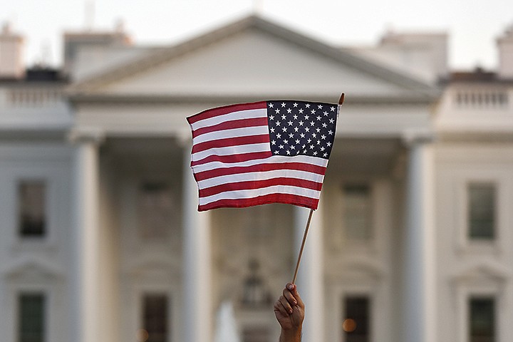 In this September 2017 file photo, a flag is waved outside the White House in Washington. The Trump administration is coming out with new visa restrictions aimed at restricting a practice known as "birth tourism." That refers to cases when women travel to the United States to give birth so their children can have U.S. citizenship.  (AP Photo/Carolyn Kaster)