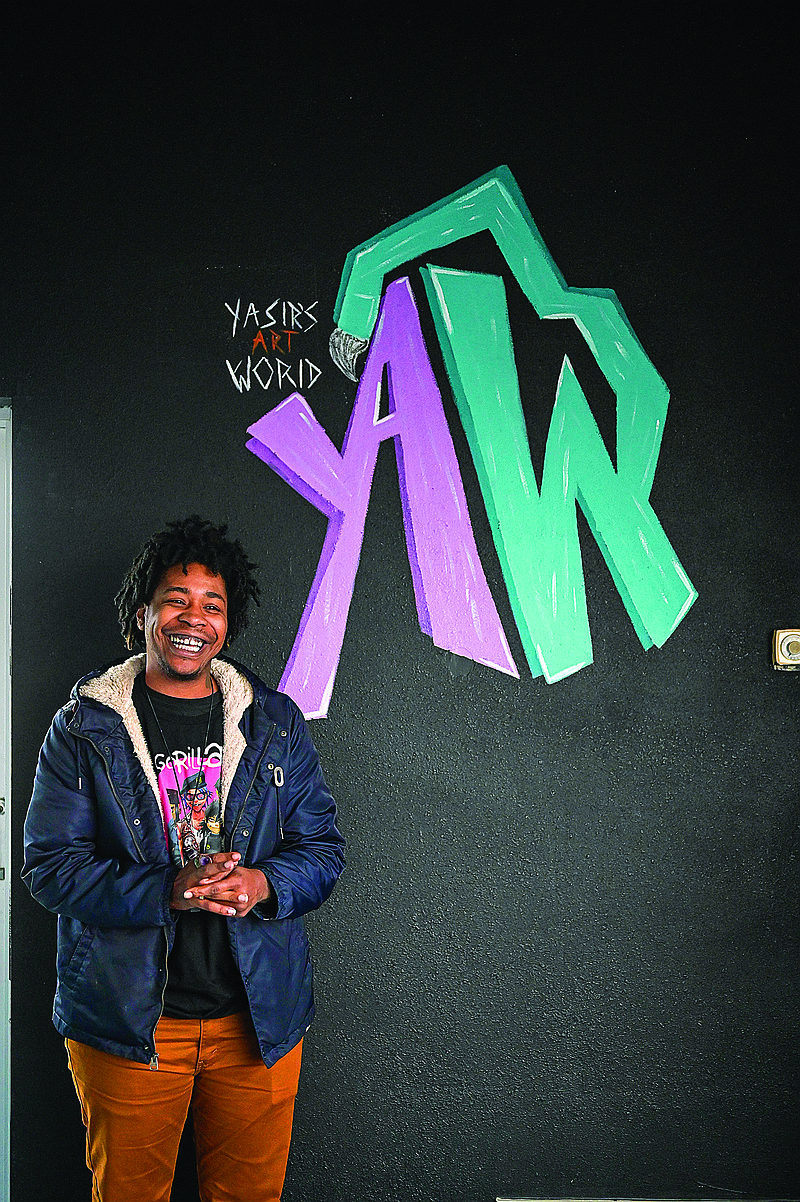 Yasir DeGrate poses for a portrait next to his logo in his new art studio, Yasir's Art World on 3420 N. State Line Ave. in Texarkana, Arkansas. 