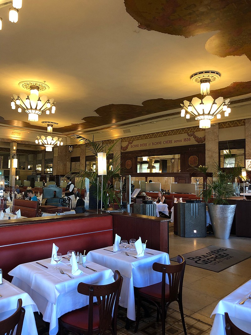 Red banquettes and art deco chandeliers adorn the elegant, historical dining room at Brasserie Georges. (Washington Post photo by Sylvie Bigar)