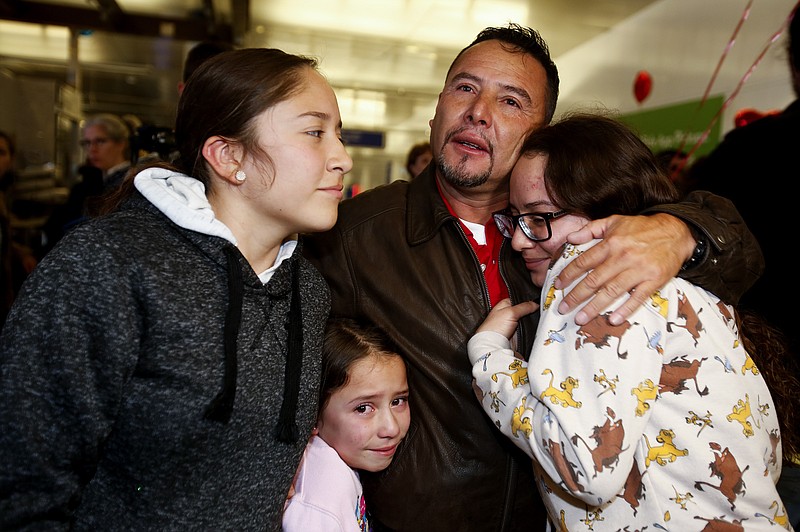 Esvin Fernando Arredondo of Guatemala reunites with his daughters Andrea, left, Keyli, right, and Alison, second from left, at Los Angeles International Airport after being separated during the Trump administration's wide-scale separation of immigrant families, Wednesday, Jan. 22, 2020, in Los Angeles. (AP Photo/Ringo H.W. Chiu)