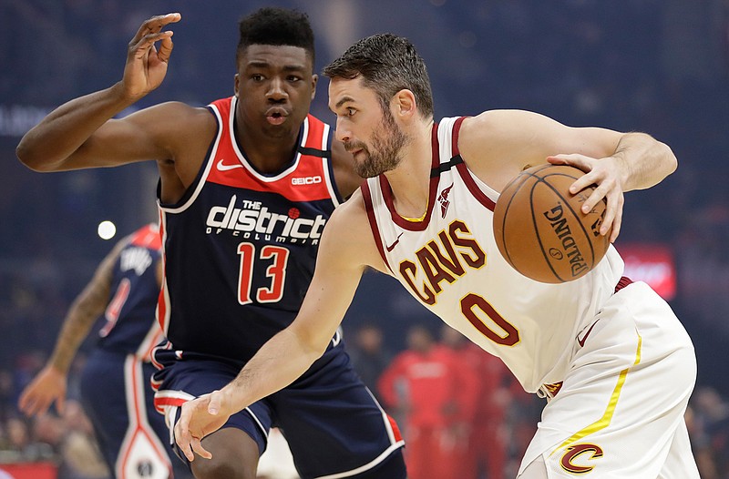 Cleveland Cavaliers' Kevin Love, right, drives past Washington Wizards' Thomas Bryant in the first half of an NBA basketball game, Thursday, Jan. 23, 2020, in Cleveland. (AP Photo/Tony Dejak)