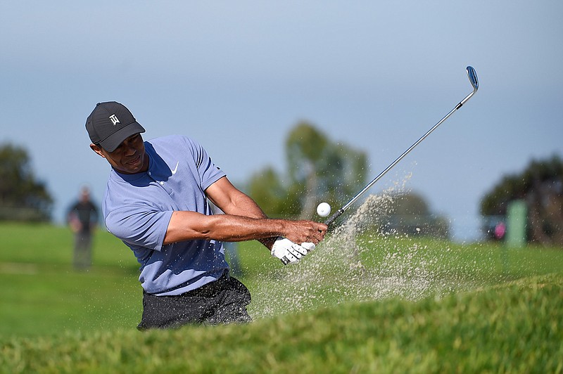 Tiger Woods hits out of the bunker on the eleventh hole of the North Course at Torrey Pines Golf Course during the first round of the Farmers Insurance golf tournament, Thursday, Jan. 23, 2020, in San Diego. (AP Photo/Denis Poroy)