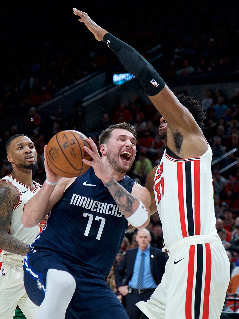 Dallas Mavericks guard Luka Doncic (77) drives to the basket past Portland Trail Blazers center Hassan Whiteside during the first half of an NBA basketball game in Portland, Ore., Thursday, Jan. 23, 2020. (AP Photo/Craig Mitchelldyer)