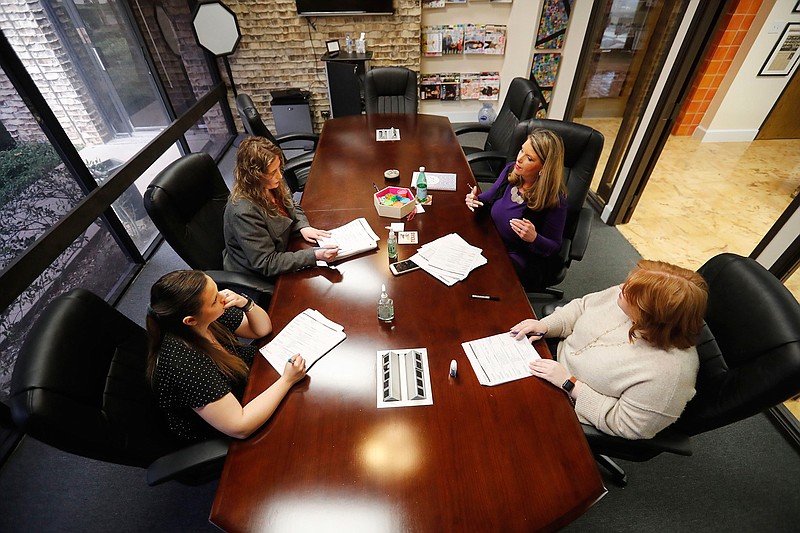 Jo Trizila, top right, President and CEO of Trizcom Public Relations, conducts a meeting with her staff Ann Littmann, right, Noel Hampton, bottom left, and Hayley Swinton at their office in Dallas, Tuesday, Jan. 21, 2020. The recent flu outbreak can really impact small businesses with small staffs and hurt a company's productivity. Some owners, like Trizila, are trying to mitigate the damage so the flu will not become a nightmare when they're trying to get clients' work done. (AP Photo/LM Otero)