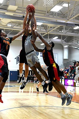 Joe Davis of Lincoln battles three Pittsburg State players for control of the ball during last Saturday's game at Jason Gym.