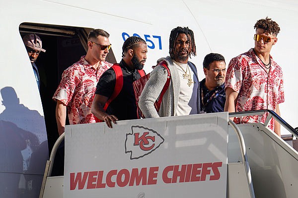 Patrick Mahomes (far right) and his Chiefs teammates get off the plane Sunday after arriving in Miami for Super Bowl LIV.