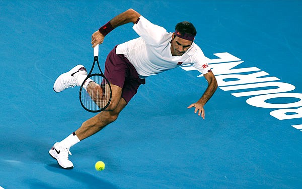Roger Federer runs to make a backhand return to Marton Fucsovics during their fourth-round singles match Sunday at the Australian Open in Melbourne, Australia.