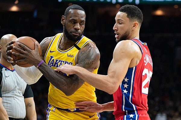 LeBron James of the Lakers tries to make his move on Ben Simmons of the 76ers during a game Saturday night in Philadelphia.