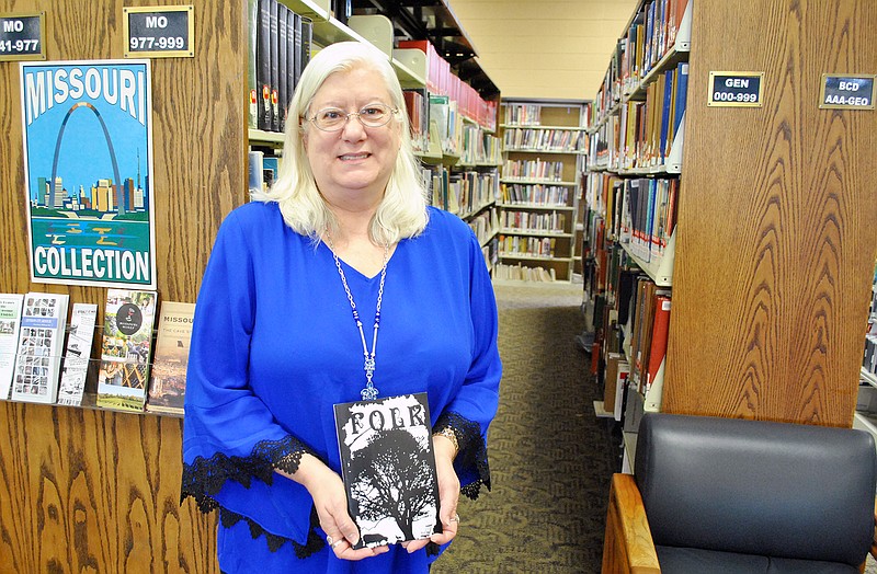 <p>File photo</p><p>Kimberly Bolton holds her poetry book “Folk” at the Missouri River Regional Library.</p>