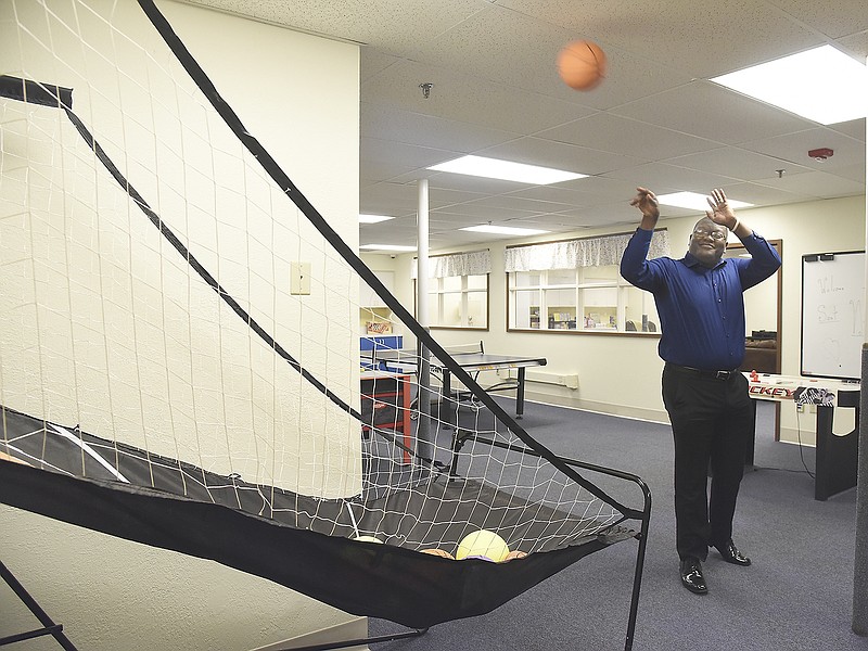 Funtez Robinson shoots the ball in the pop-a-shot net Monday in the game room at St. Nicholas Academy. Robinson and his wife, Unique, will serve as house parents for the all-boys academy, located at 1310 Edgewood Drive.