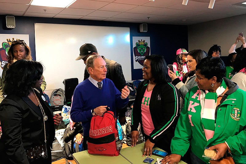 In this Jan. 20, 2020, photo, former New York City Mayor and presidential candidate Michael Bloomberg talks to volunteers assembling backpacks at Scholarmade Achievement Place in Little Rock, Ark. (AP Photo/Andrew DeMillo)