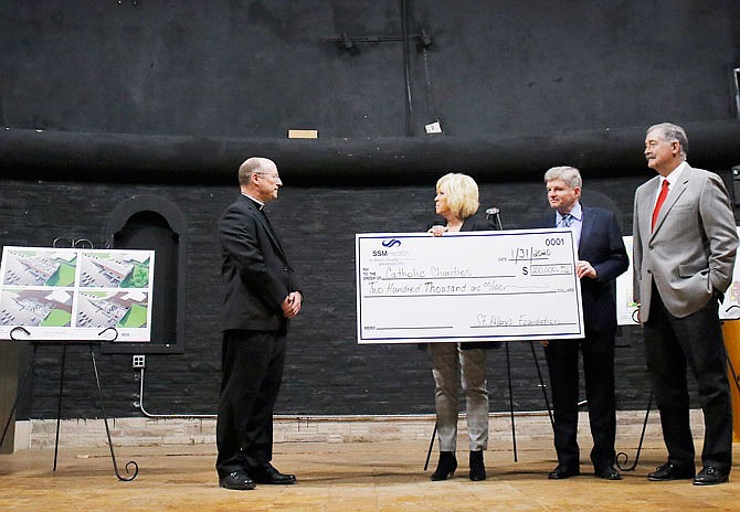 Representatives from St. Mary's Foundation present Bishop W. Shawn McKnight with a $200,000 check Friday to help with the renovation of Catholic Charities of Central and Northern Missouri's new building, the Shikles Auditorium on Linden Drive. 