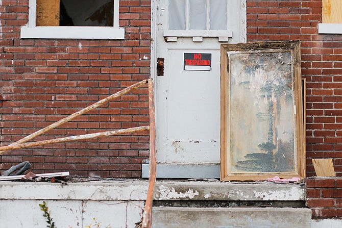 A painting is propped up Friday against the front door of a gutted house on the corner of Jackson and Dunklin streets. The house across the street from it is long gone now, after the May 22 tornado hit. 