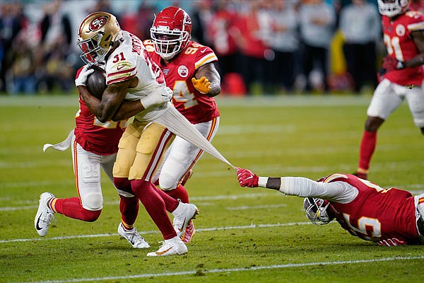 Chiefs defensive end Frank Clark tries to tackle 49ers running back Raheem Mostert during the first half of the Super Bowl LIV game Sunday night in Miami Gardens, Fla.