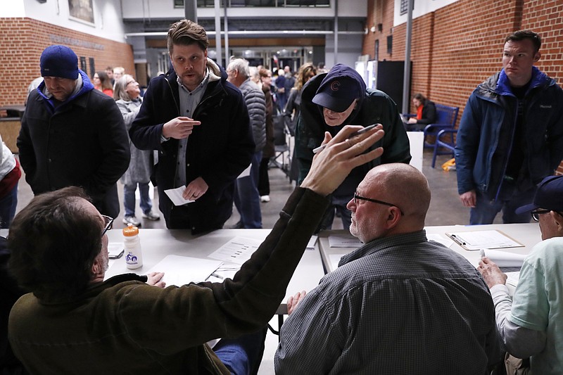 Caucus goers check in at a caucus at Roosevelt High School, Monday, Feb. 3, 2020, in Des Moines, Iowa. (AP Photo/Andrew Harnik)