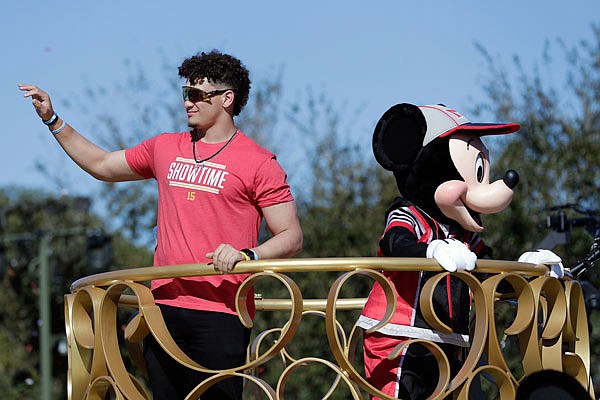 Chiefs quarterback Patrick Mahomes and Mickey Mouse wave to fans during a parade Monday at the Magic Kingdom theme park at Walt Disney World in Lake Buena Vista, Fla.