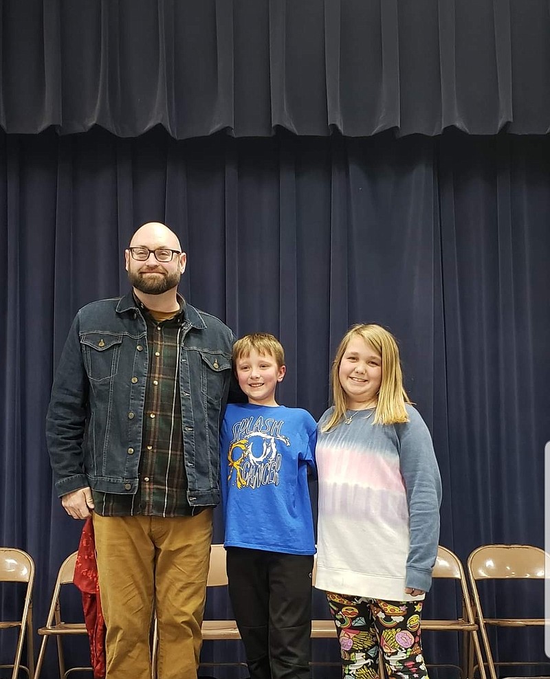 Fifth-grader Olivia Blacklock, right, was the spelling bee champion, while fifth-grader Emerson Reinhardt, center, took second place. District librarian Justin Hamm, left, organized the spelling bee.