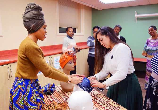 Leeajiah Harvard, left, a headwrapping enthusiast, teaches Val Fuimaono a simple technique Tuesday at the Callaway County Public Library. Headwrapping is a good way to add pizzazz to an outfit or conceal a bad hair day, Harvard said.