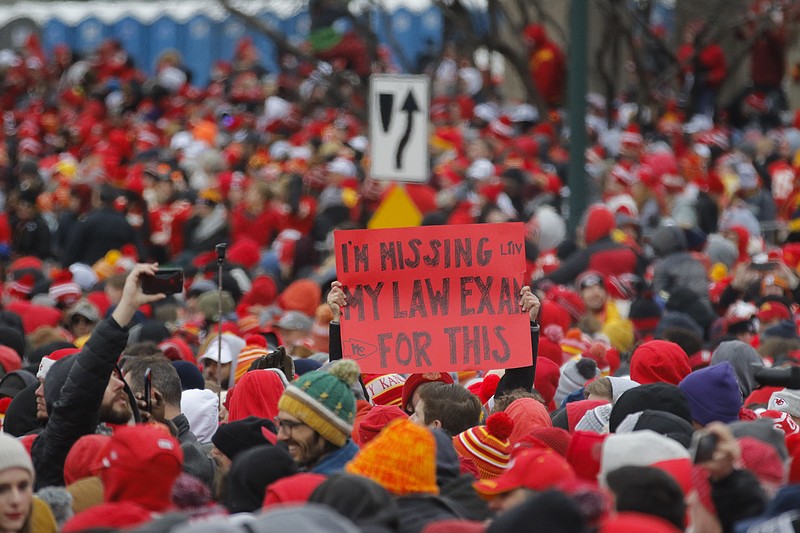 An unfortunate — or perhaps a very fortunate — law student raises a sign amid the hordes of Chiefs fans Wednesday at the intersection of Pershing and Main streets in downtown Kansas City.