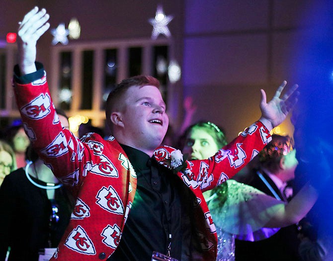 Mason Keathley raises his arms at the DJ of the night, Mark Landis, as Landis cuts the music to a song Friday, Feb. 7, 2020, so the audience has to sing it during the Night to Shine prom at the Capital West Christian Church Event Center. (News Tribune photo)