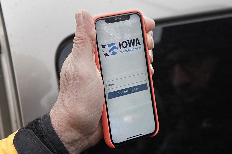 Precinct captain Carl Voss of Des Moines displays the Iowa Democratic Party caucus reporting app on his phone outside of the Iowa Democratic Party headquarters in Des Moines, Iowa, Tuesday, Feb. 4, 2020. (AP Photo/Nati Harnik)