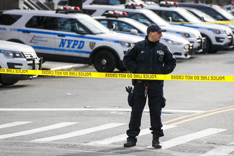 New York police set up a perimeter outside the 41st police precinct at the scene of a police involved shooting, Sunday, Feb. 9, 2020, in New York. (AP Photo/John Minchillo)