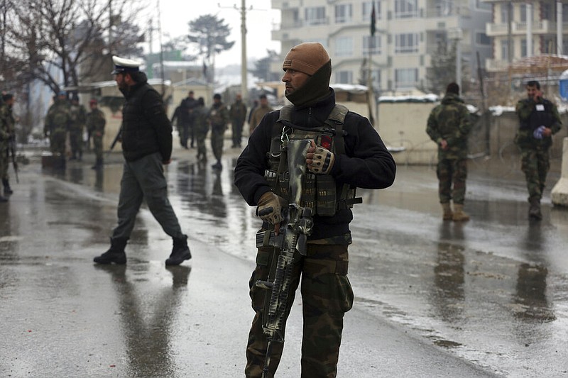 National army soldiers stand guard at the site of suicide attack near the military academy in Kabul, Afghanistan, Tuesday, Feb. 11, 2020. A suicide bomber targeting a military academy in the Afghan capital on Tuesday killed at least six people, including two civilians and four military personnel, the Interior Ministry said. (AP Photo/Rahmat Gul)