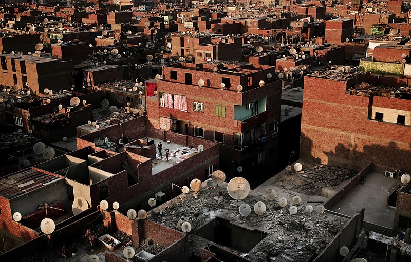 FILE - In this Aug. 13, 2017 file photo, girls play on a rooftop in Boulaq El Dakrour district of Giza, Egypt. On Tuesday, Feb. 11, 2020, the official statistics agency announced Egypt’s fast-growing population hit 100 million people, presenting a pressing problem for an already overburdened country with limited resources. The figure is an increase of 7 million since the publication of the latest census results in 2017. (AP Photo/Nariman El-Mofty, File)