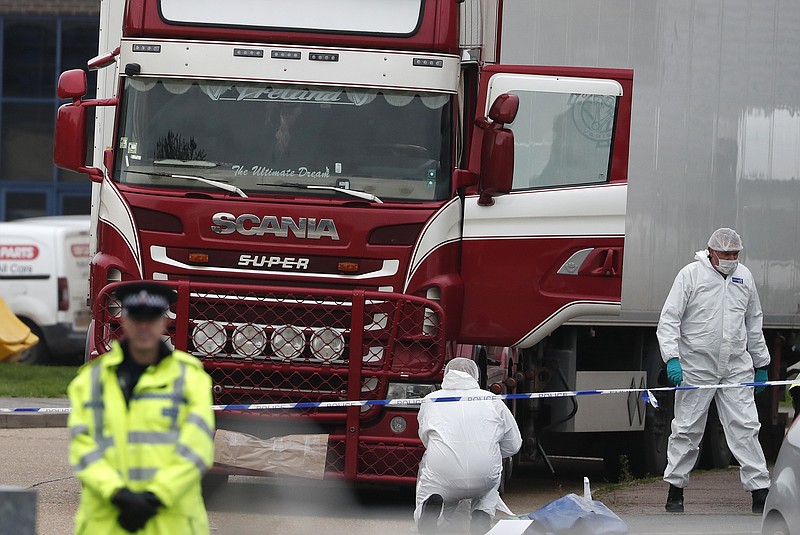 FILE - In this file photo dated Wednesday Oct. 23, 2019, Police forensic officers attend the scene after a truck was found to contain a large number of dead bodies, in Grays, South England.  Police said Tuesday Feb. 11, 2020, that a provisional postmortem examination of 39 bodies found inside this shipping container in England concluded that the victims from Vietnam died of a combination of insufficient oxygen and overheating in a closed space.  Police said Feb. 11, they are continuing to make progress in a complex investigation. (AP Photo/Alastair Grant, FILE)