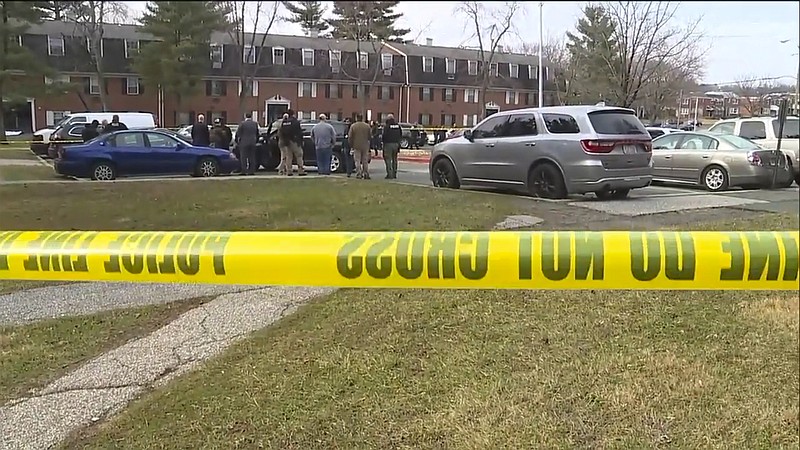 This image provided by WMAR-2 News shows emergency and law enforcement officials responding to the scene of a shooting,  Wednesday, Feb. 12, 2020 in Baltimore.  Two law enforcement officers with a fugitive task force were injured and a suspect died in a shooting on Wednesday, the U.S. Marshals Service said. (WMAR-2 News via AP)