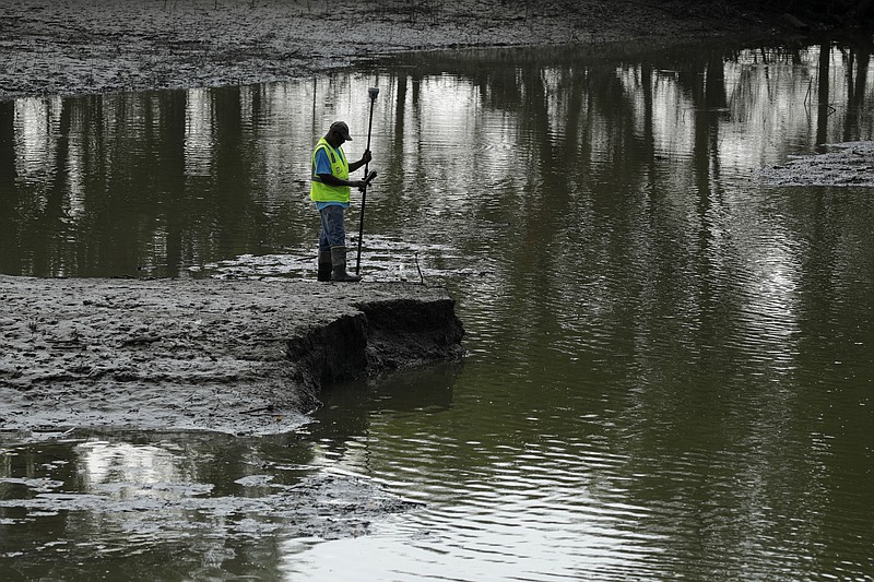 FILE - In this Aug. 6, 2019, file photo, U.S. Army Corps of Engineers worker Ron Allen uses a GPS tool to survey the extent of damage where a levee failed along the Missouri River near Saline City, Mo.  (AP Photo/Charlie Riedel, File)