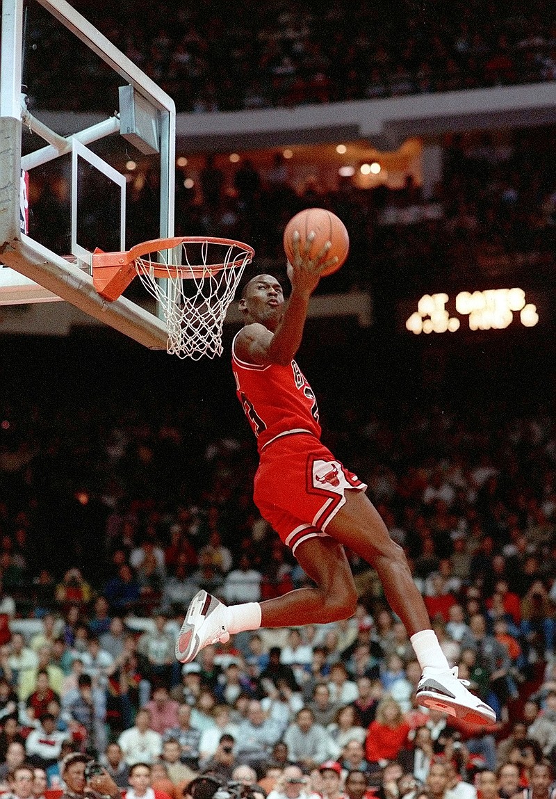 In this Feb. 6, 1988, file photo, Chicago Bulls' Michael Jordan dunks during the slam-dunk competition of the NBA All-Star weekend in Chicago.  Jordan left the old Chicago Stadium that night with the trophy. To this day, many believe Wilkins was the rightful winner.  (AP Photo/John Swart)