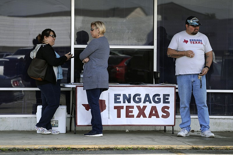 In this Tuesday, Jan. 28, 2020 photo, canvassers with Engage Texas, a political super PAC, seek to sign up voters while set up outside a driver's license office in San Antonio, Texas. With their base not expanding and their margins of victory getting thinner, Texas Republicans have begun spending big on finding more conservatives to vote. (AP Photo/Eric Gay)