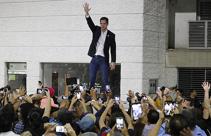 Opposition leader Juan Guaido waves to supporters during a rally at Bolivar Plaza in Chacao,  a municipality of Caracas, Venezuela, Tuesday, Feb. 11, 2020. Guaido returned home from a tour of nations that back his effort to oust socialist leader Nicolas Maduro. (AP Photo/Ariana Cubillos)