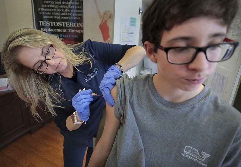 FILE - In this Jan. 3, 2019, file photo, Wendy Kerley gives Ethan Getman, 15, a shot of the flu vaccine at the Cordova Shot Nurse clinic in Memphis, Tenn. A second wave of flu is hitting the U.S., turning this into one of the nastiest flu seasons for children in a decade. (Jim Weber/Daily Memphian via AP, File)