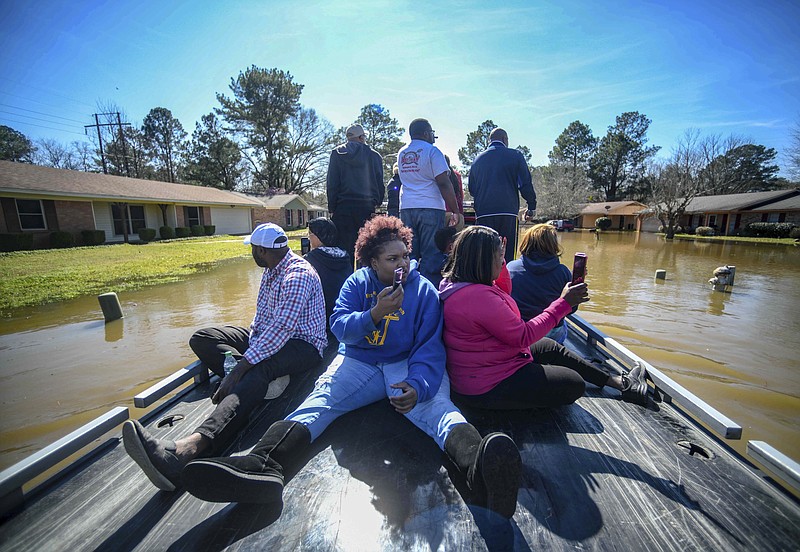 Residents of Canton Club Circle subdivision in Northeast Jackson, Miss., use a boat to get to flooded homes Saturday, Feb. 15, 2020. (Cam Bonelli/Hattiesburg American via AP)