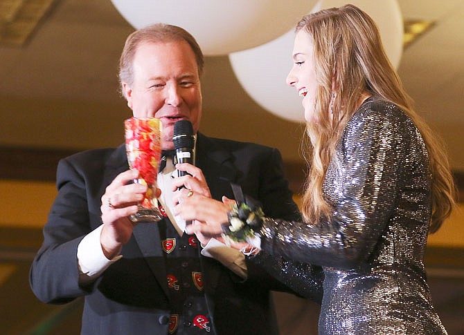Greta Hinds, a student at Helias Catholic High School and the 2020 Heart Star of the Mid-Missouri Heart Ball, receives a special Kansas City Chiefs Super Bowl glass filled with confetti from the Super Bowl game from KRCG's Rod Smith on Saturday at the 29th annual Mid-Missouri Heart Ball at the Capitol Plaza Hotel and Convention Center.
