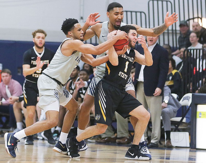 Lincoln guards Marcel Burton (right) and Cameron Potts try to steal the ball from Fort Hays State guard Aaron Nicholson during the second half of Saturday's game at Jason Gym.