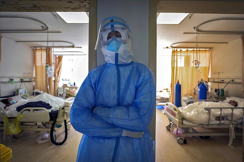 In this Sunday, Feb. 16, 2020, photo, a medical worker takes a nap at a hospital in Wuhan in central China's Hubei province. Chinese authorities on Monday reported a slight upturn in new virus cases and hundred more deaths for a total of thousands since the outbreak began two months ago. (Chinatopix via AP)