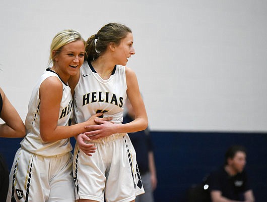 Emily Harrison (left) congratulates Helias teammate Kylie Bernskoetter after Bernskoetter scored a basket during Monday nights game against Southern Boone at Rackers Fieldhouse.