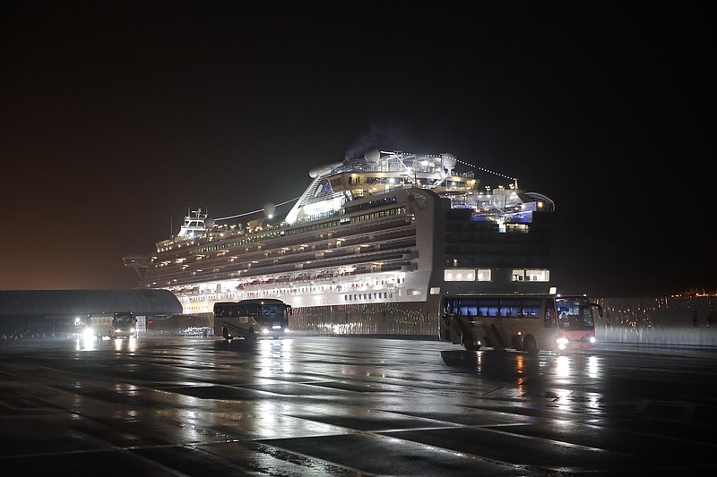 FILE - In this Feb. 17, 2020, file photo, buses carrying American passengers from the quarantined Diamond Princess cruise ship leave a port in Yokohama, near Tokyo. After 14 days, an extraordinary quarantine of the Diamond Princess cruise ship ends Wednesday, with thousands of passengers and crew set to disembark over the next several days in the port of Yokohama. (AP Photo/Jae C. Hong, File)