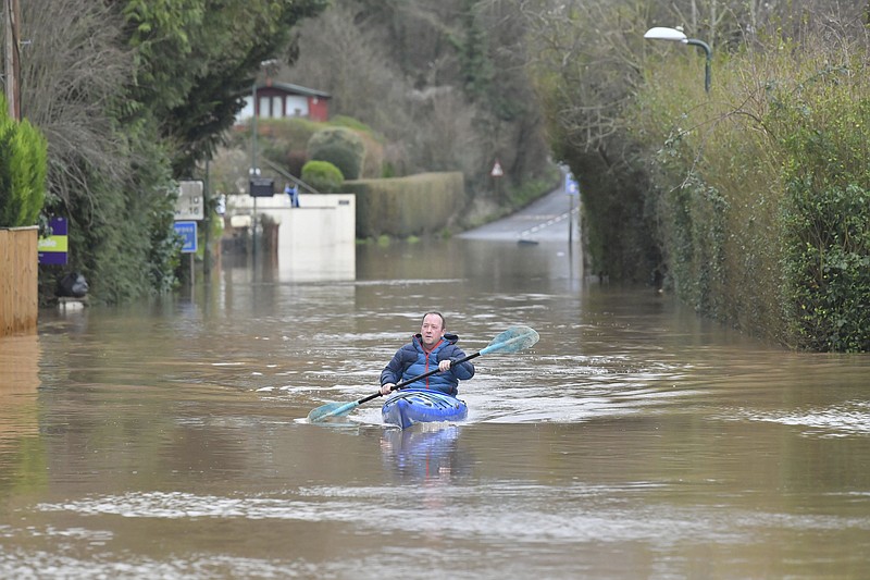 A man travels by boat through floodwater in Monmouth, Wales, Tuesday Feb. 18, 2020. Britain's Environment Agency issued severe flood warnings Monday, advising of life-threatening danger after Storm Dennis dumped weeks' worth of rain in some places. (Ben Birchall/PA via AP)