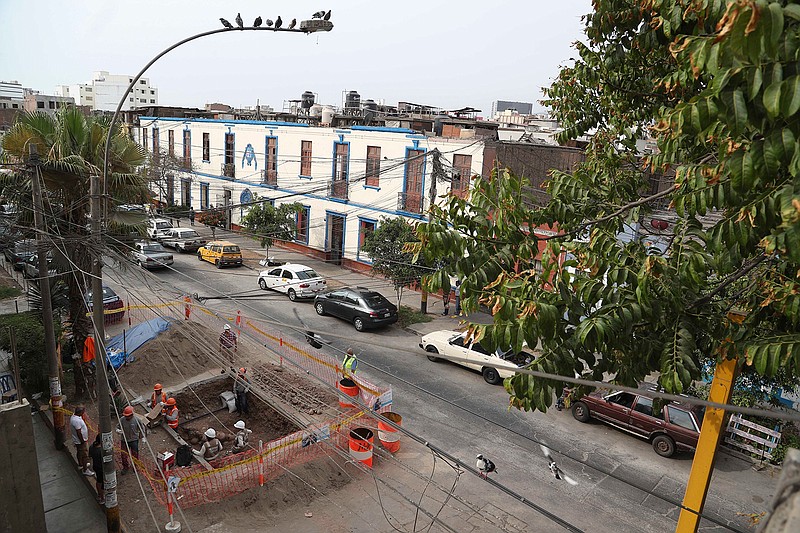 In this Feb. 11, 2020 photo, gas workers and archaeologists clean an area where ancient bones and vessels from a previous Inca culture were discovered in the Brena neighborhood of Lima, Peru. About 300 archaeological finds, some 2,000 years old, have been reported over the past decade during the building of thousands of kilometers (miles) of natural gas pipelines in the capital. (AP Photo/Martin Mejia)