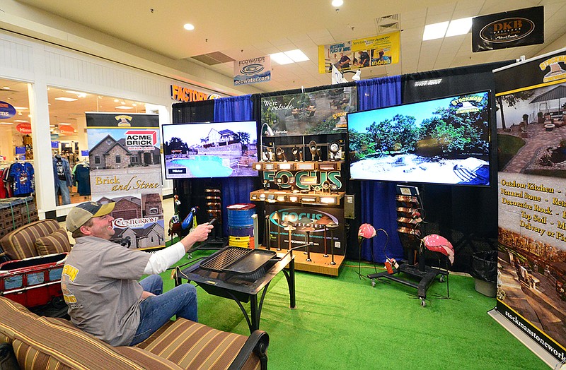 Matt Mertens, of Stockman Stoneworks, changes channels on a video player in their booth at the Home Builders Association Home Show at the Capital Mall in 2019. The HBA Home Show is set for Friday and Saturday. 