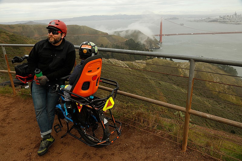 San Francisco residents Matt Dove, 41, and his son Elijah, 3, take a break from riding their e-bike at Hawk Hill, which overlooks the Golden Gate Bridge, in Marin, Calif. on Jan. 24, 2020. (Genaro Molina/Los Angeles Times/TNS)