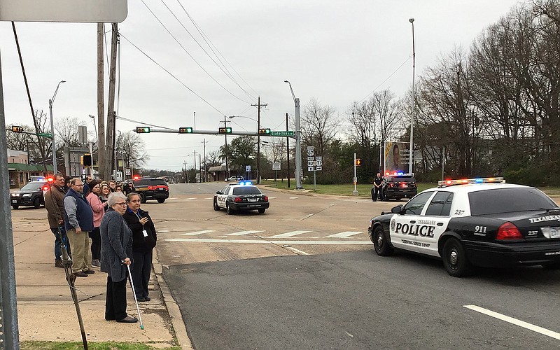 A group stands at Martin Luther King Jr. Boulevard in honor of Texarkana College Police Officer Damon Lynn as law enforcement officers from across the region escort his body Wednesday to East Funeral Home in Texarkana.