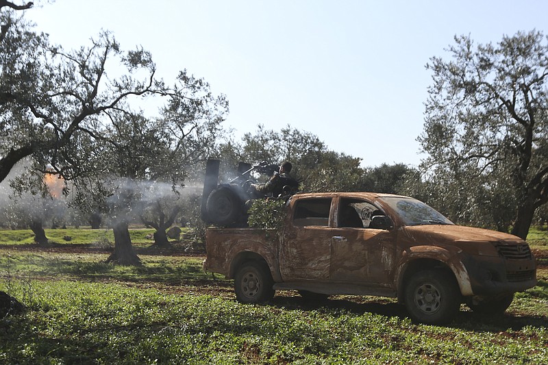 Turkish backed rebel fighters fire heavy machine gun near the village of Neirab in Idlib province, Syria, Thursday, Feb. 20, 2020. Two Turkish soldiers were killed Thursday by an airstrike in northwestern Syria, according to Turkey's Defense Ministry, following a large-scale attack by Ankara-backed opposition forces that targeted Syrian government troops. (AP Photo/Ghaith Alsayed)